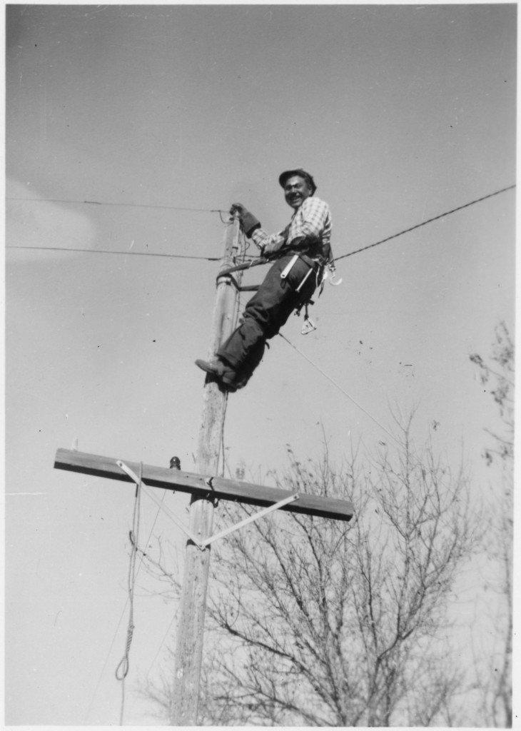 A lineman on a telephone pole.